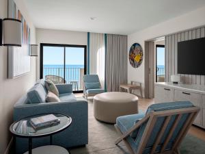 乔治敦Grand Cayman Marriott Resort的客厅配有沙发、椅子和电视