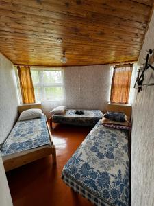 KaunataVasaras mājiņa Nr.3的客房设有三张床和木制天花板。