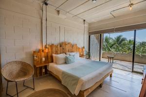 女人岛Mayan Monkey Isla Mujeres的一间卧室设有一张大床和一个大窗户