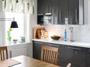 哈尔姆斯塔德Holiday home Halmstad XII的厨房配有黑色橱柜和木桌