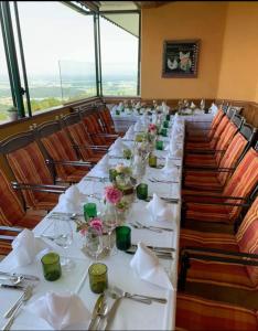 绍萨尔地区基策克斯特瑞尔兰德全景酒店的一张长桌,房间配有白色的桌子和椅子