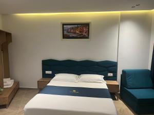 卡萨米尔Agimi Hotel的一间卧室配有一张床和一张蓝色椅子