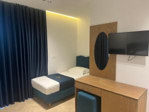 卡萨米尔Agimi Hotel的一间小卧室,配有一张床和一台平面电视