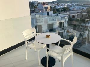 卡萨米尔Agimi Hotel的阳台上配有一张白色的桌子和两把椅子