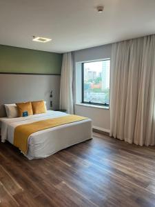 圣保罗蓝树维波迪维努顶级酒店的一间卧室设有一张大床和一个大窗户