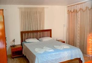 贝贝里比Pousada Villa Mariposa的一间卧室配有一张带两条白色毛巾的床