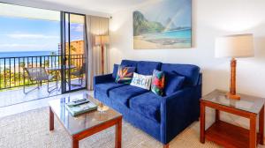 拉海纳Maui Westside Presents: Kaanapali Shores 733 Stunning Ocean Views NEW LISTING的一间带蓝色沙发的客厅和一个阳台