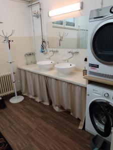 奥斯特菲尔登3 Monteurzimmer als Wohngemeinschaft zur Selbstversorgung的一间带两个盥洗盆和洗衣机的浴室