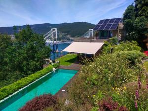 维戈A magical, beautiful villa,stuning views的享有带游泳池和桥梁的房屋的顶部景致