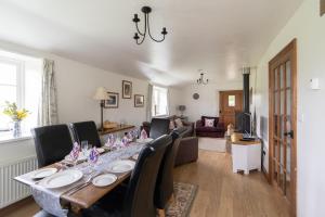 洛克斯顿Coachmans Cottage in Loxton的一间带长桌和椅子的用餐室