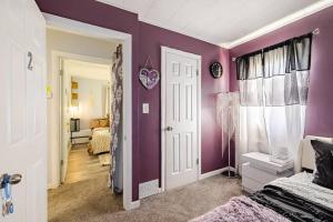 Elegant Serene Escape in Wyandotte的卧室设有紫色墙壁、床和门