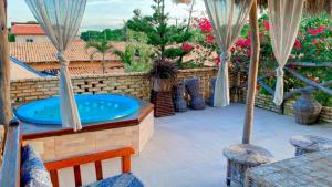 贝贝里比Pousada Villa Mariposa的庭院内的热水浴池,配有椅子和鲜花