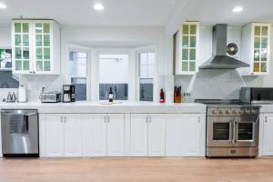 East Palo AltoVilla Palo Alto的厨房配有白色橱柜和不锈钢用具