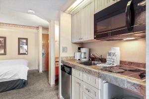 布雷肯里奇Beaver Run Resort 4705 by Great Western Lodging的一个带水槽的厨房和一张位于客房内的床