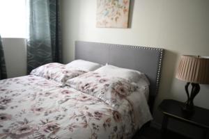 尼亚加拉瀑布Metropolitan Suite的一间卧室配有一张带鲜花毯子和灯的床。