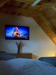 Enjoy the quiet nature in our unique cottage的卧室的墙上设有平面电视