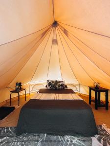 兰金Glamping Guayaha的帐篷内的一张床位,配有两张桌子