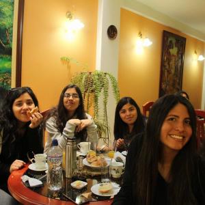 卡哈马卡Retamas Hotel EIRL的四个坐在餐桌上吃食物的女人