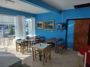 比瓜苏Pousada Catarina的一间带桌椅和蓝色墙壁的餐厅