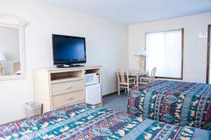 威斯康星戴尔星光汽车旅馆的配有一张床和一台平面电视的酒店客房