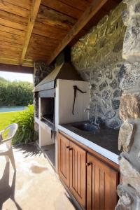 阿苏尔Cabañas Las Tahonas的一个带水槽和石墙的厨房