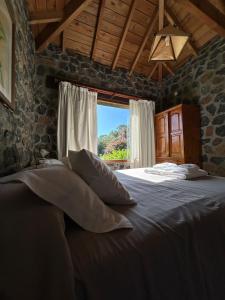 阿苏尔Cabañas Las Tahonas的卧室配有带枕头的床铺和窗户。