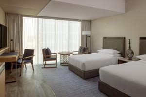 迪拜Marriott Marquis Dubai的酒店客房配有两张床和一张书桌