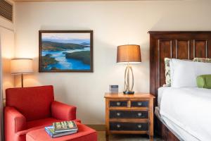 贝灵厄姆Hotel Bellwether on Bellingham Bay的一间卧室配有一张床和一张红色椅子
