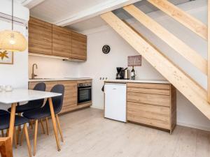 罗莫柯克比Holiday home Rømø XV的厨房配有木制橱柜和桌椅
