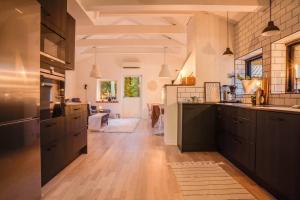 英斯约Swedish Costal Forest Hideaway的一间设有黑色橱柜的大厨房和一个客厅