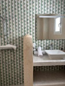 艾西拉RIAD OASIS D'ASILAH的一间带水槽和镜子的浴室