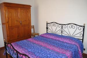 皮恩扎La Ginestra的一间卧室配有一张床和一个木制橱柜