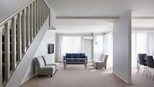 堪培拉品尼克公寓式酒店的客厅设有蓝色椅子和楼梯