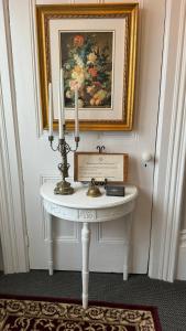 皮克顿The 1885 Suites的一张带蜡烛的白色桌子和墙上的绘画