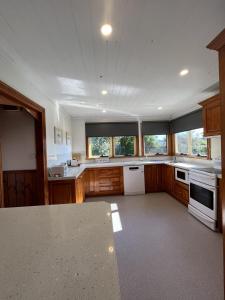 比舍诺Seaview Apartment - Tidelines of Bicheno的一个带木制橱柜和白色家电的大厨房