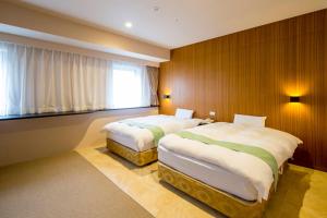 大阪新大阪酒店的一间卧室设有两张床和窗户。