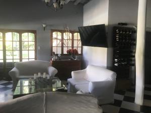 查克拉斯德科里亚Posada Pinar De Besares的客厅配有白色的椅子和桌子