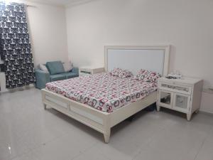 沙迦Biggest Room in Sharjah的白色卧室配有床和椅子