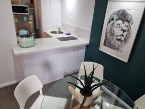 悉尼Accommodation Sydney City Centre 1 Bedroom Apartment with Balcony的一间用餐室,配有玻璃桌和狮子图片
