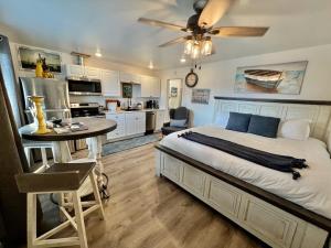 荷马Seafarer Suites的一间卧室配有一张床铺和一张桌子,还设有一间厨房