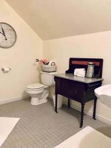 卡纳布The Founders Suite at The Historic Kanab Inn的一间带卫生间、水槽和时钟的浴室