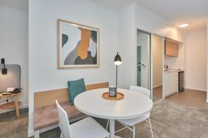 布里斯班奎斯特加农山公寓的白色的用餐室配有白色的桌椅