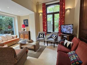 斯帕Heritage Villa in Spa with Garden的客厅配有红色家具和电视