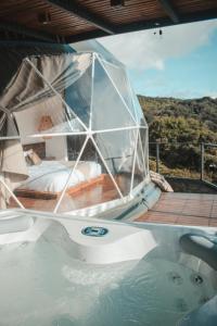 蒙泰韦尔德哥斯达黎加Ananta Forest - Glamping Dome - Hot Tub - Sunset & Gulf View的船上的浴缸,床上的床铺