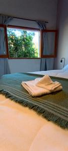 科洛尼亚卡罗亚casa de campo, Bodega Di Candi的卧室床上的毛巾