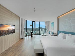 下龙湾Luxury 5 Star A La Carte Residence Ha Long的一间带大床的卧室和一间客厅
