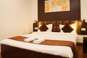甘托克Hotel Siddhi Vinayak Regency,near Mg Marg, Gangtok的一间卧室配有一张大床和两条毛巾