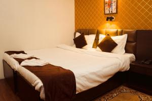 甘托克Hotel Siddhi Vinayak Regency,near Mg Marg, Gangtok的一间卧室配有带白色床单和枕头的床。