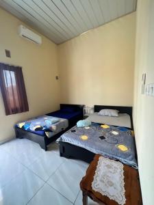 特尔纳特岛KBI Hostel的客房设有两张床和窗户。