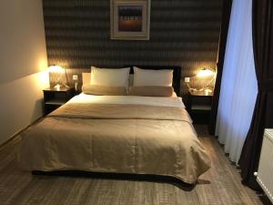 Razgrad米莫扎酒店的一间卧室配有一张大床和两盏灯